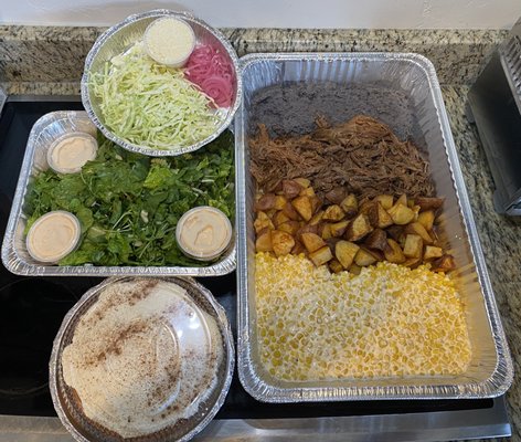 Shredded beef tostadas, street corn, potatoes, black beans, salad, and tres leches cake