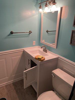 This bathroom had flooring , wainscoting , vanity , paint and lighting done after removing tons of wallpaper !