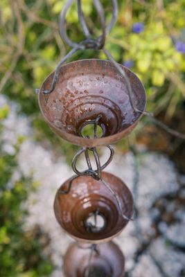 The water flows down rain chains. An alternative to downspouts.