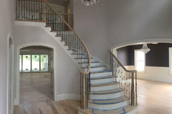 This curved staircase with bowed treads and traditional handrail and balusters was built and installed by Andronic's Construction