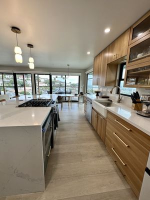 Modern open kitchen with island and waterfall edge countertop.