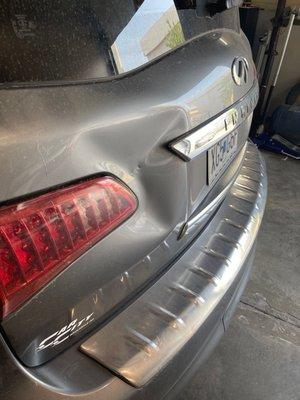 Damage on a rear hatch caused by vehicle backing into a dumpster