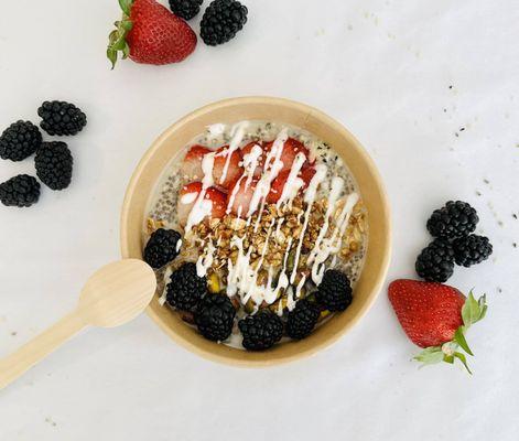 Chia seeds, spices, gluten-free oat milk, maple syrup, organic berries, almond milk yogurt, and homemade granola topping.