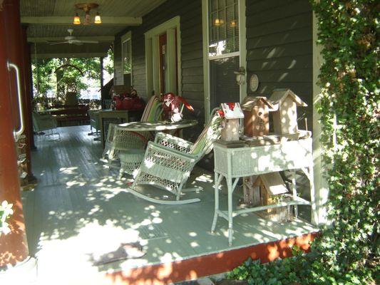 Covered front porch with glider and swings for relaxing.