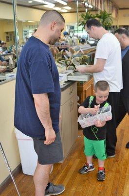 Dad and son, head out, well groomed, with a lollipop from the assorted selection in hand.