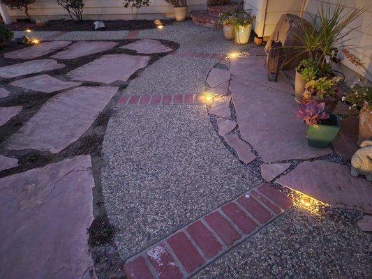 Low voltage lighting installed along an exposed aggregate walkway.