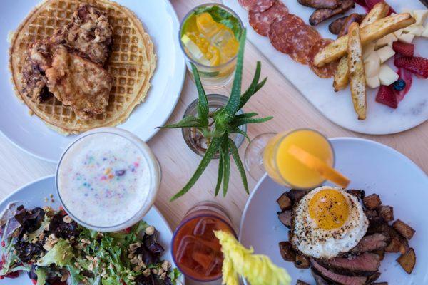 Brunch Featuring Bloodies, Mimosas, Cereal Cocktails, a Mango Mojito, Steak & Eggs, Salad, Chicken & Waffles, and Charcuterie.