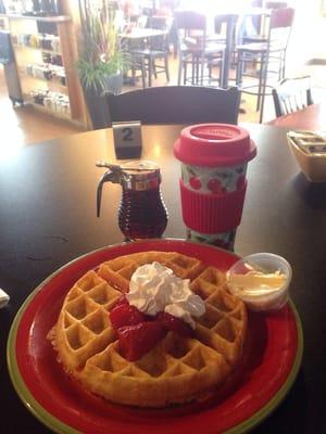 Belgium waffles with strawberries and whipped cream.