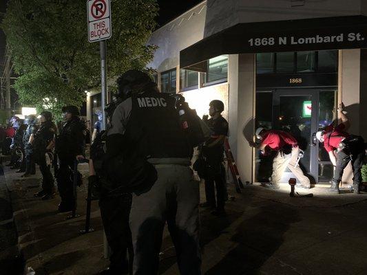 riot kkkop line/blockade and carpenters sealing up the windows of the ORCOPS building