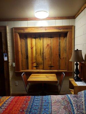 Table, chairs and window with pine shutters.