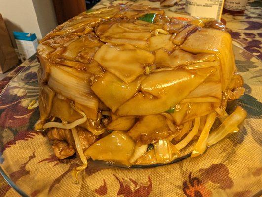 Beef Chow Fun flipped over onto a glass plate.