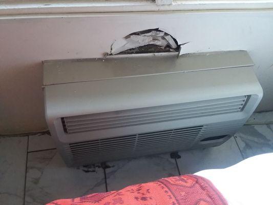 Hole in wall above noisy air conditioner