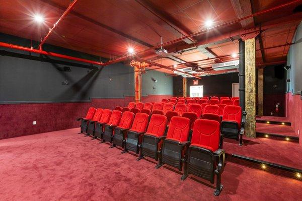 Our 72 seating screening room with red velvet seats and industrial features has a classic movie theater feel perfect for your next event.