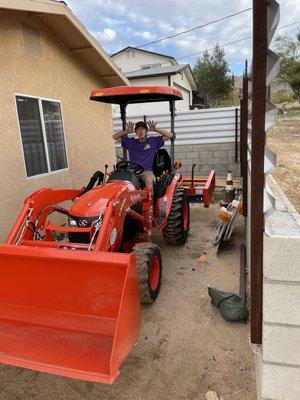 My son getting ready to build dirt bike jumps in the back yard.