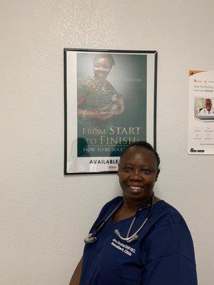 The doctor posing next to her picture.