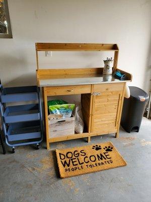 Gardening workbench with storage plus small rolling cart with three shelves for added storage and easy transport of large or heavy items.