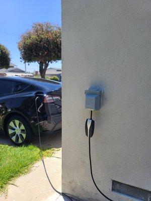 Outdoor nema 14-50 in weatherproof enclosure for Electric Vehicle charging. Wire run came from the backyard of the home.