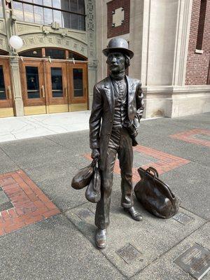 The bronze sculpture of a traveler  harkening to the bygone days of train travel.