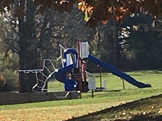 The smallish playground has multiple slides and climbing features.