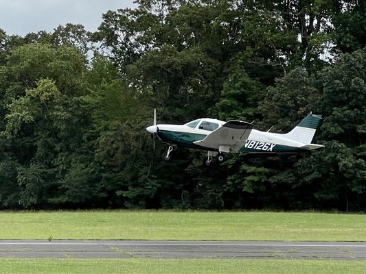 Plane taking off from the runway right in front of the restaurant.