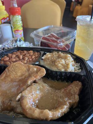 Fried smothered pork chops, rice and gravy, and pinto beans. Red velvet cake for dessert and an Arnold Palmer to drink.