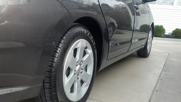 Exterior of Prius shining. It has droplets of water on it due to the rain.