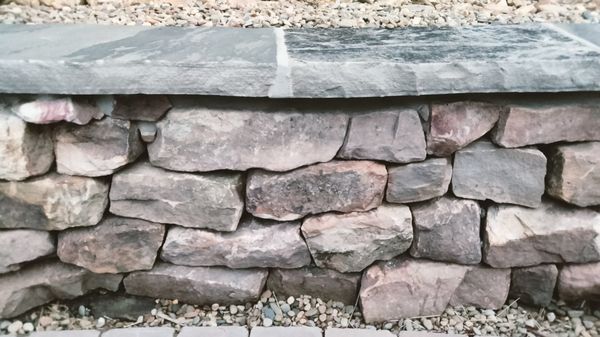 Drystack retaining wall with mortared capstone.