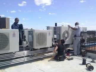 Crew installing conduit and wiring ductless ac units in Harlem.