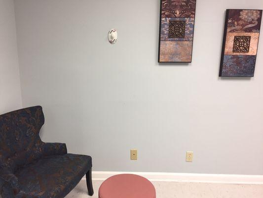 Homey chairs and walk art in exam room