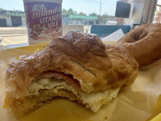 Ham, cheese, egg croissant, cake donut and milk to drink it down.