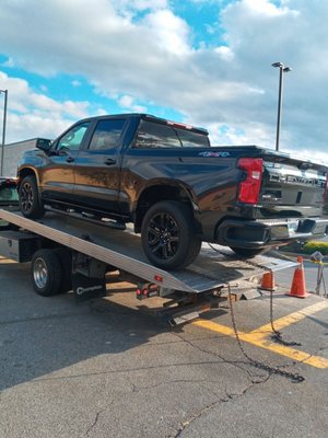 My broken down 2020 Chevy Silverado being loaded onto a flat bed tow truck