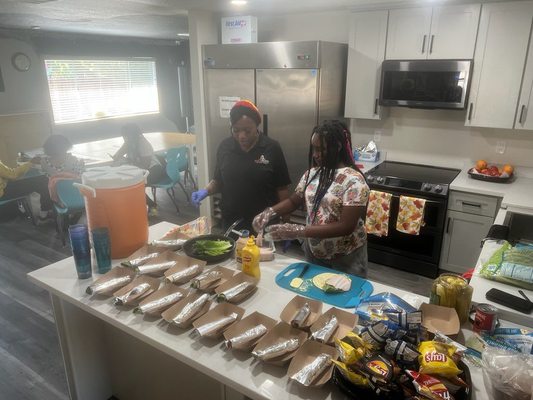 Ms. M serving up food with one of our kiddos