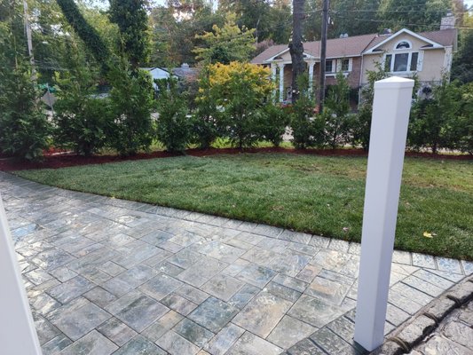 Beautiful backyard patio with privacy hedge by Bianco's Landscaping & Masonry.