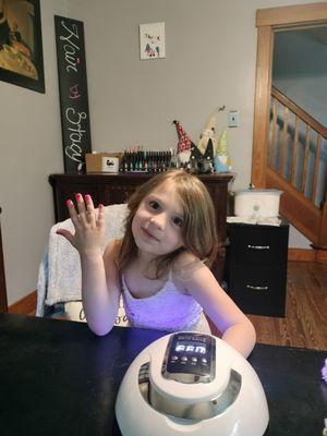 Little girl getting gel polish rainbow nails