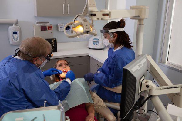 Dr. Solow cleaning a client's teeth.