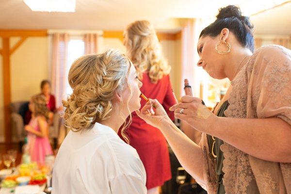 Stunning blonde bride with amazing updo getting makeup