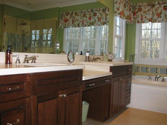 This master bath has cherry double vanities with corian countertops.