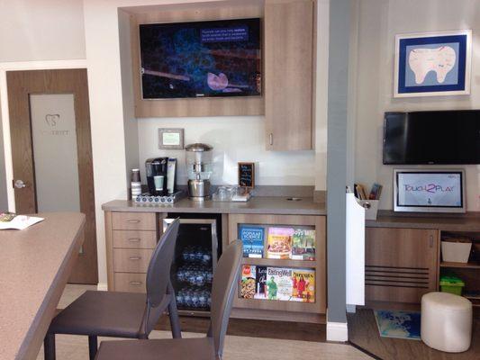 Beverage station in lobby,  including coffee & bottled water. To the right is a cubicle stocked with interesting things for kids to do.