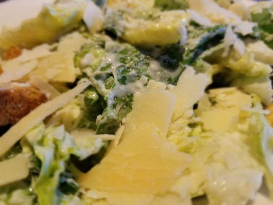 Ceasar side salad. Fresh greens and cheese. Heavily dressed.