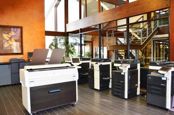 Digital Office Systems' product demonstration room including Konica Minolta & Ricoh copiers, wide format printers, and production printers.