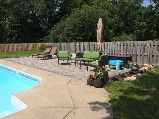 3 ft boulder wall in back with elevated patio, surrounded by mulch and flowers