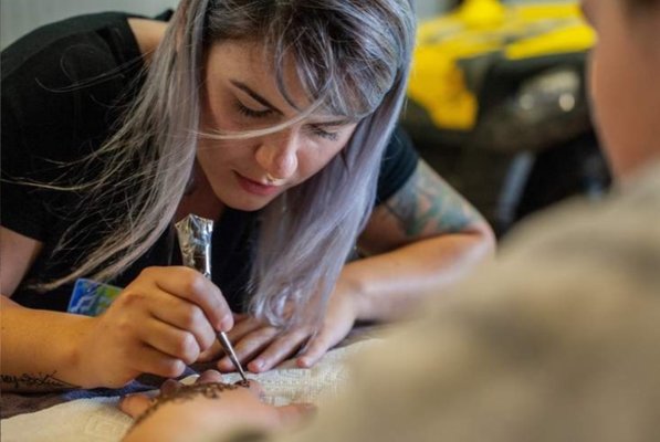 Deonna, owner of Good Vibes Yoga Studio, applying a henna tattoo. Please contact if interested in henna.