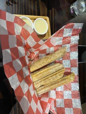 Churros filled with dulce de leche with a dipping sauce