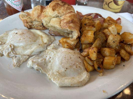 Breakfast platter over easy, home fries, bacon and croissant