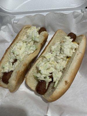 2 vegan hot dogs with vegan slaw () and mustard.