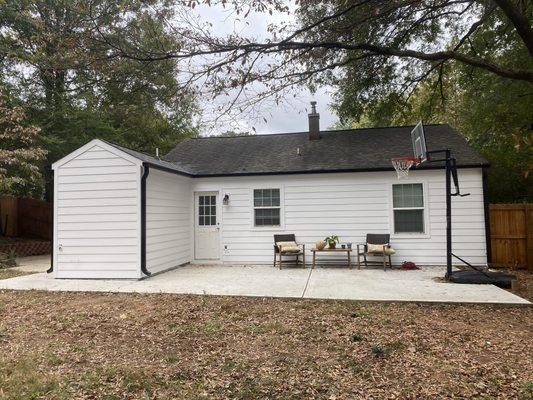 New concrete siding with black gutters