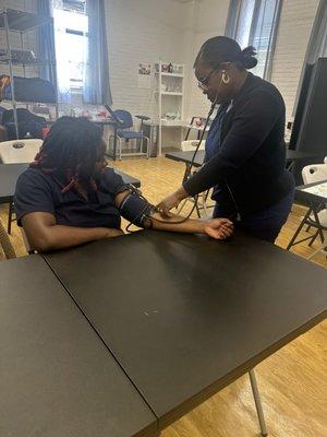 Medical Assistant student taking blood pressure