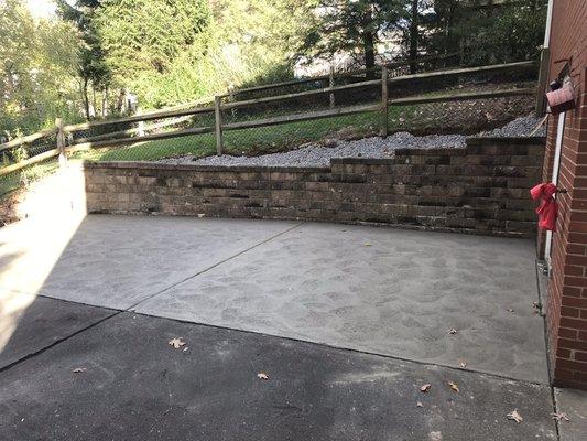 Reconstructed retaining wall with new concrete pad