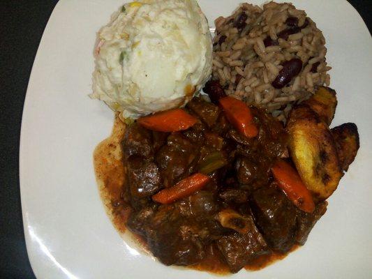 Stewed Goat served with Vegan Potato Salad, Red Beans and Rice and Plantain.