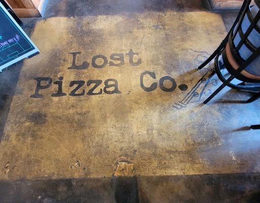 The sign on the floor at the entrance of the restaurant.